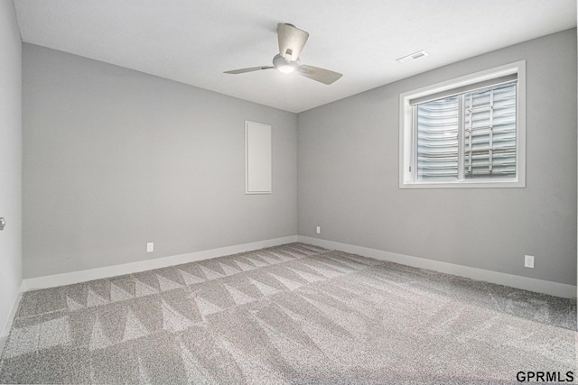 empty room with visible vents, baseboards, carpet, and a ceiling fan