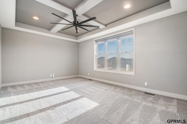 carpeted spare room featuring a ceiling fan, baseboards, visible vents, coffered ceiling, and beam ceiling