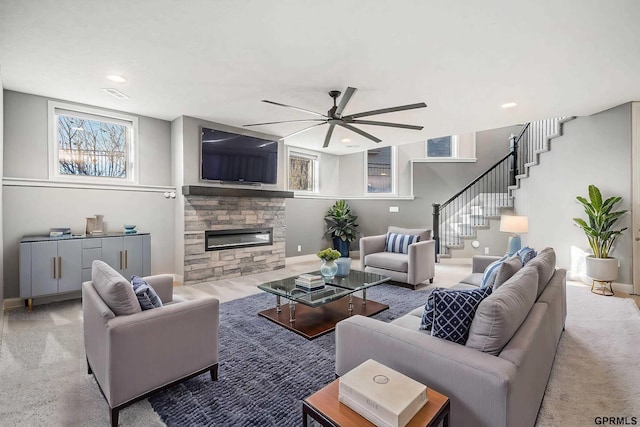 carpeted living area featuring a ceiling fan, recessed lighting, a fireplace, baseboards, and stairs