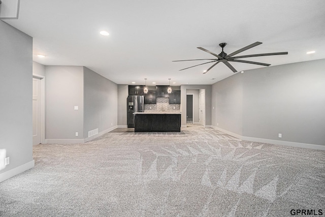 unfurnished living room featuring visible vents, a ceiling fan, recessed lighting, baseboards, and light colored carpet