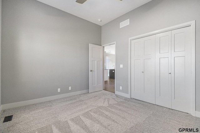 unfurnished bedroom with carpet flooring, baseboards, visible vents, and a closet