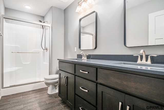 bathroom featuring a stall shower, wood finish floors, and a sink