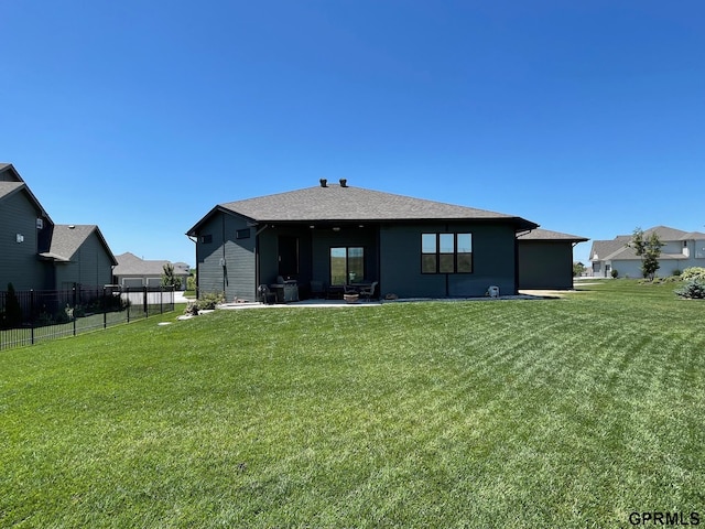 back of property with a patio area, a lawn, and fence