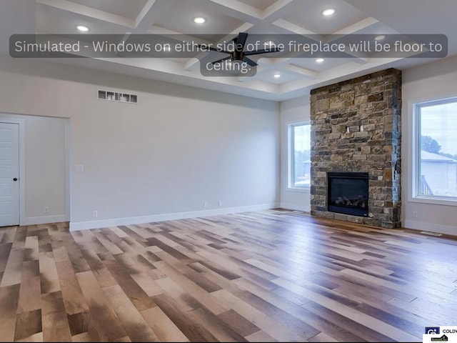 unfurnished living room with a wealth of natural light, visible vents, coffered ceiling, and wood finished floors