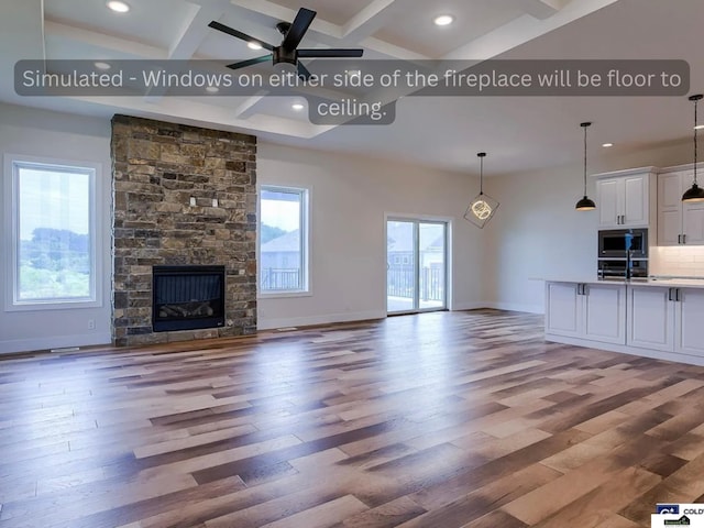 unfurnished living room featuring beam ceiling, a ceiling fan, light wood-type flooring, and coffered ceiling