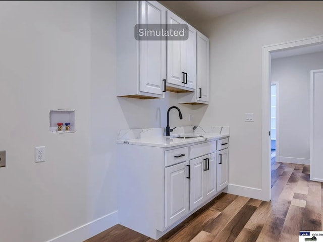 laundry area with a sink, cabinet space, dark wood-type flooring, and hookup for a washing machine