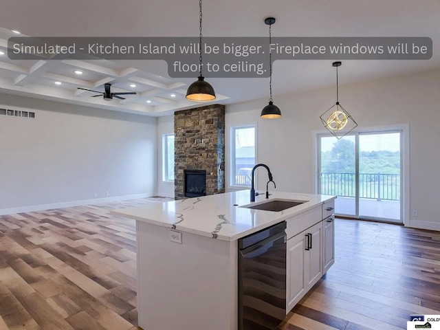 kitchen featuring a sink, light wood-type flooring, coffered ceiling, and dishwasher