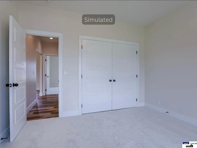 unfurnished bedroom featuring a closet, baseboards, and carpet flooring