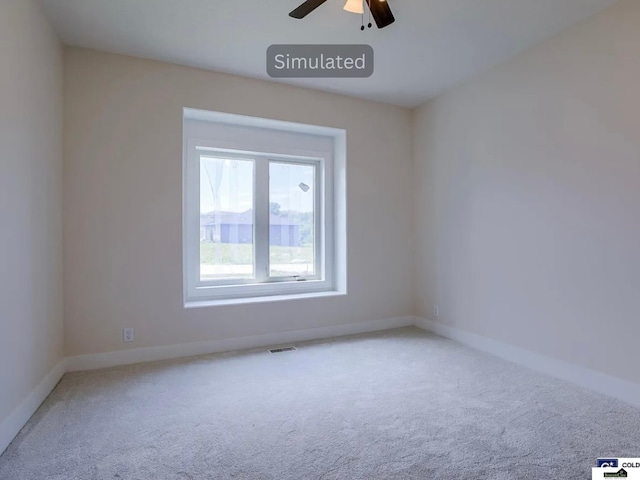 carpeted empty room with baseboards, visible vents, and ceiling fan