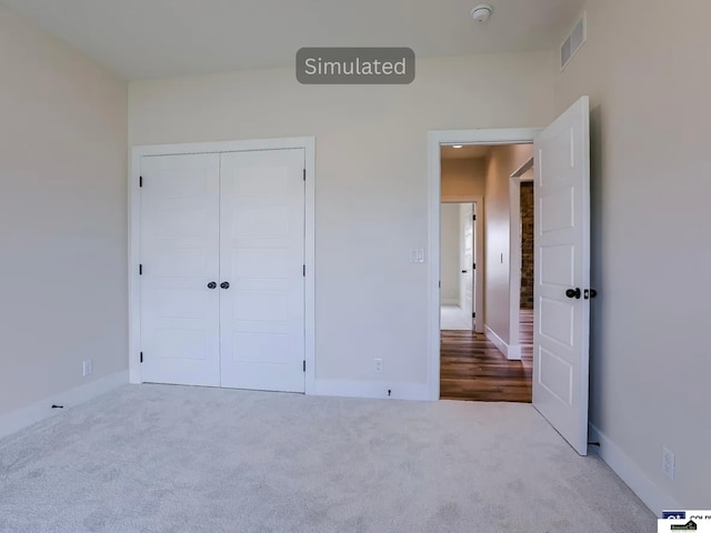 unfurnished bedroom with visible vents, baseboards, carpet, and a closet