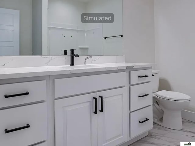 bathroom featuring vanity, toilet, and marble finish floor