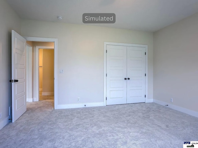 unfurnished bedroom with a closet, baseboards, and carpet