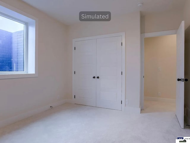 unfurnished bedroom featuring carpet flooring, baseboards, and a closet