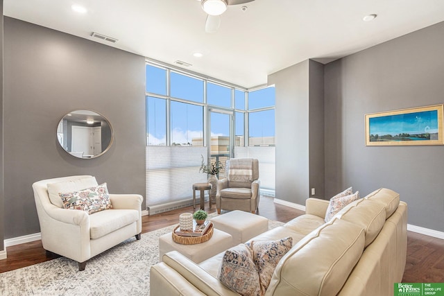 living area with visible vents, a ceiling fan, baseboards, and dark wood-style flooring