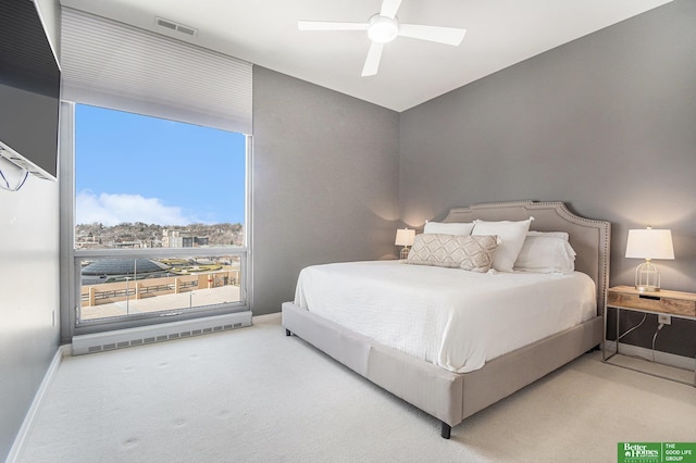 bedroom featuring visible vents, ceiling fan, baseboards, a wall of windows, and carpet floors