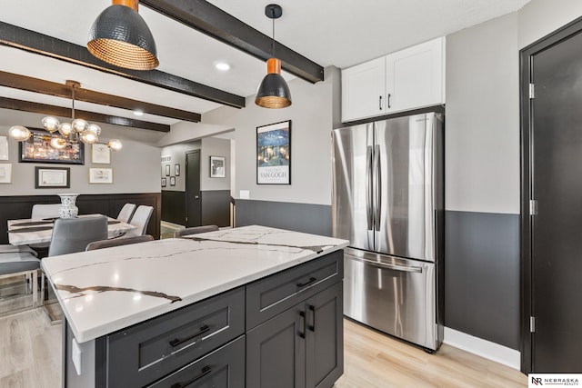 10230 Weir St, Ralston, NE 68127 - kitchen with light stone counters, beam ceiling, freestanding refrigerator, white cabinets, and light wood-style floors