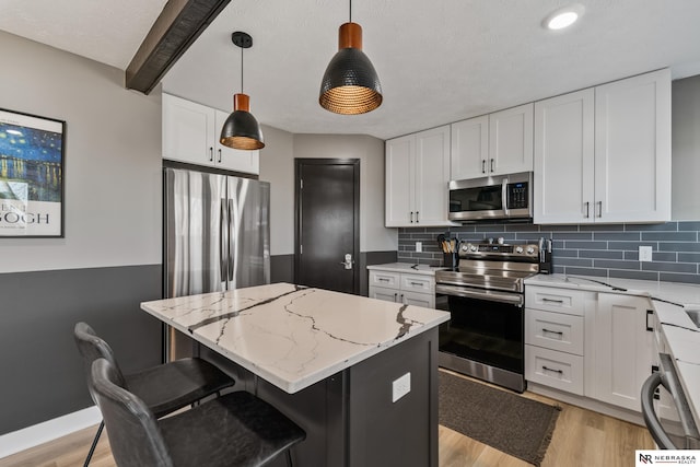 10230 Weir St, Ralston, NE 68127 - kitchen featuring backsplash, appliances with stainless steel finishes, light wood-style flooring, and a center island