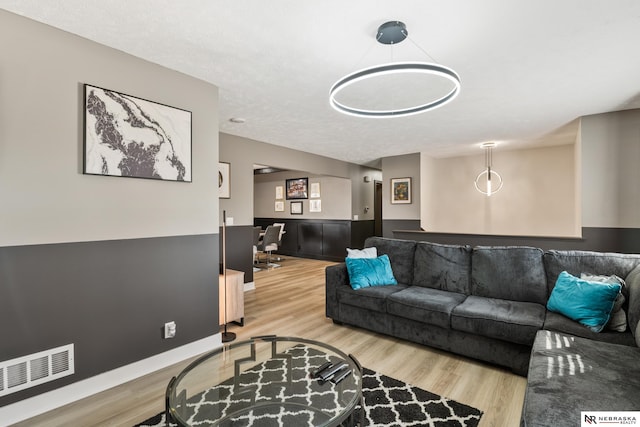 10230 Weir St, Ralston, NE 68127 - living room with wood finished floors, visible vents, and wainscoting