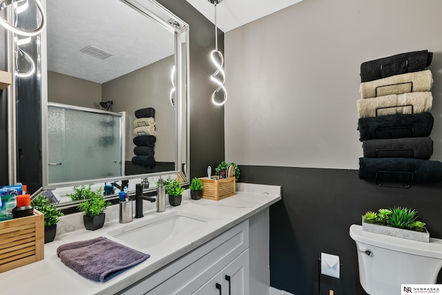 10230 Weir St, Ralston, NE 68127 - bathroom featuring visible vents, toilet, a stall shower, and vanity