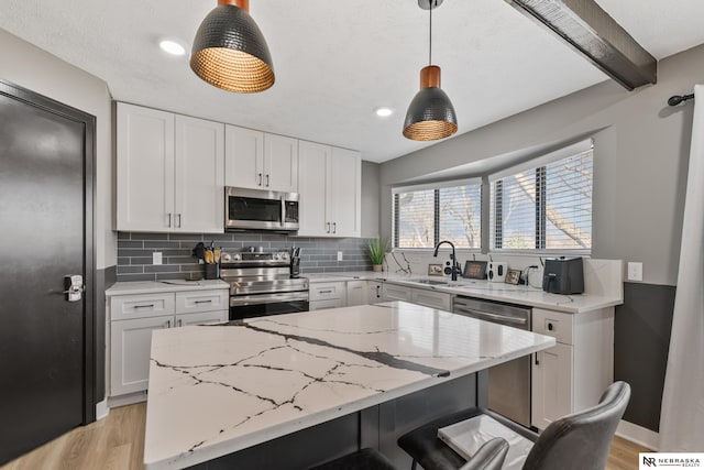 10230 Weir St, Ralston, NE 68127 - kitchen with a sink, backsplash, appliances with stainless steel finishes, white cabinets, and light wood finished floors
