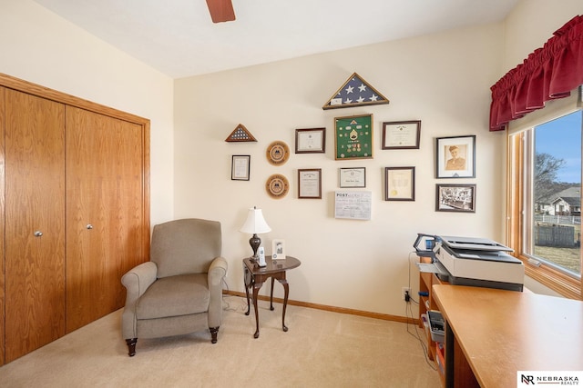 office space featuring a ceiling fan, light colored carpet, and baseboards