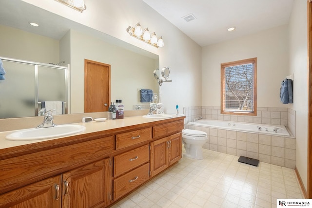 full bath with a shower stall, double vanity, visible vents, and a sink