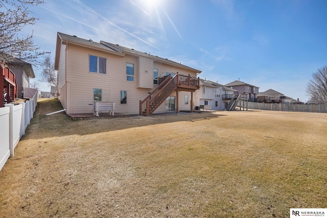 rear view of house featuring stairs, a yard, fence, and a wooden deck