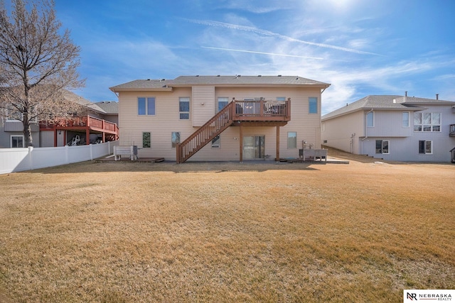 rear view of house featuring a lawn, stairs, a deck, and fence