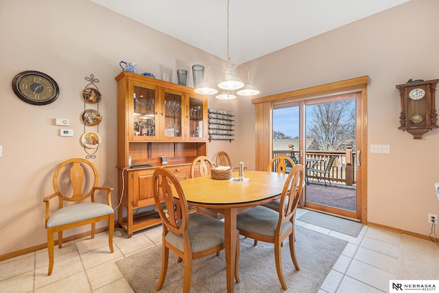 dining area with a notable chandelier, baseboards, and light tile patterned floors