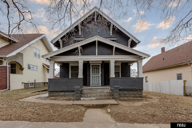 view of front of home featuring fence and covered porch