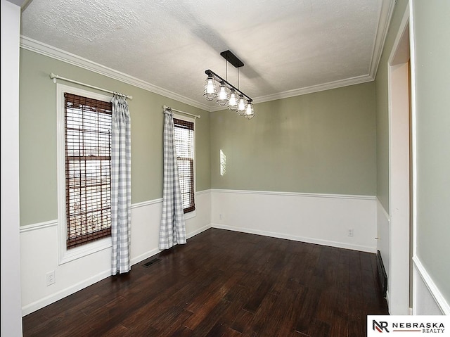 spare room featuring visible vents, a textured ceiling, wood finished floors, and ornamental molding