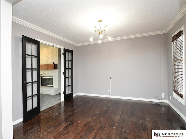 spare room with french doors, an inviting chandelier, and wood finished floors