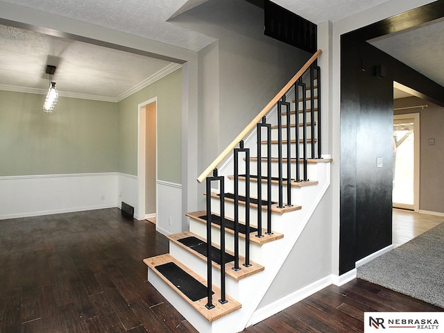 staircase with baseboards, wood-type flooring, and a textured ceiling