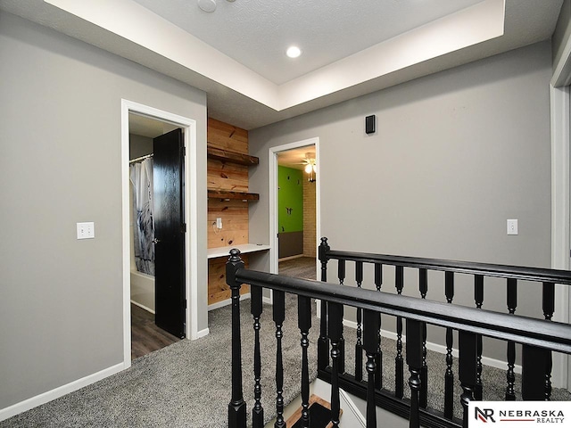 hallway with wooden walls, recessed lighting, carpet, and baseboards