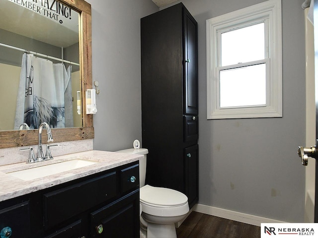 full bath with vanity, a shower with shower curtain, wood finished floors, baseboards, and toilet