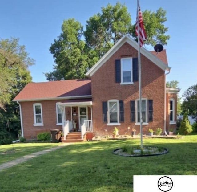 traditional-style home with a front lawn and brick siding