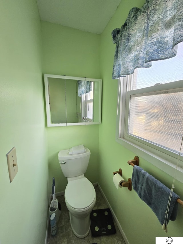 bathroom with toilet and baseboards