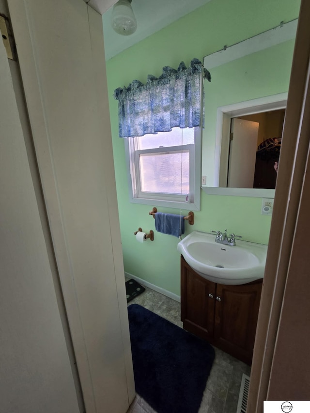 bathroom with visible vents, baseboards, and vanity