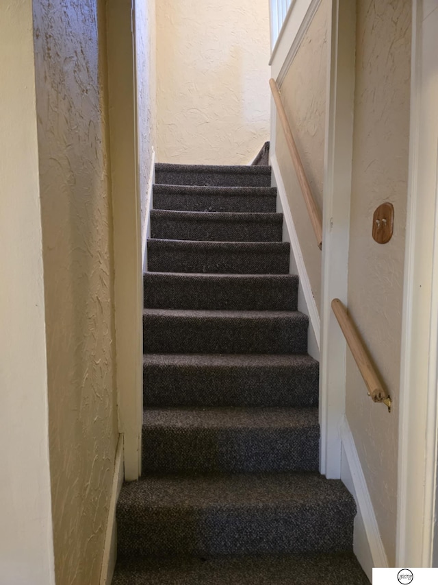 staircase featuring a textured wall