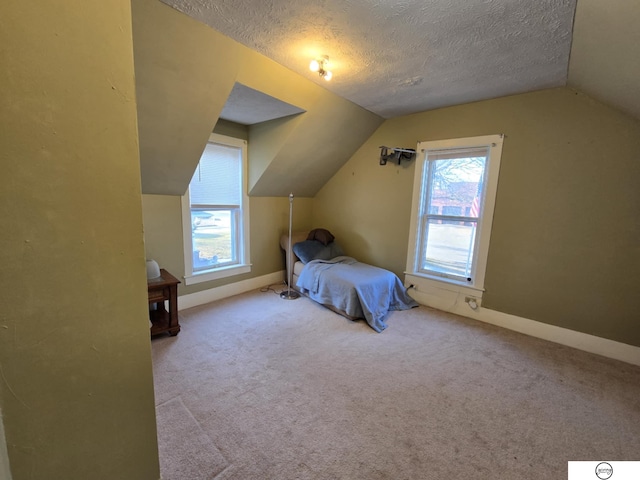 bedroom with multiple windows, a textured ceiling, lofted ceiling, and carpet floors