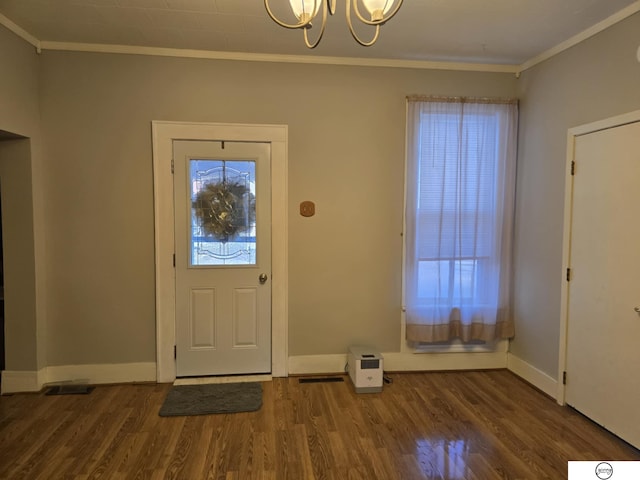 entryway featuring baseboards, wood finished floors, a chandelier, and crown molding