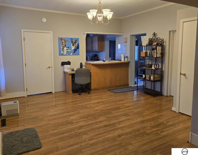 office featuring a sink, an inviting chandelier, wood finished floors, and crown molding