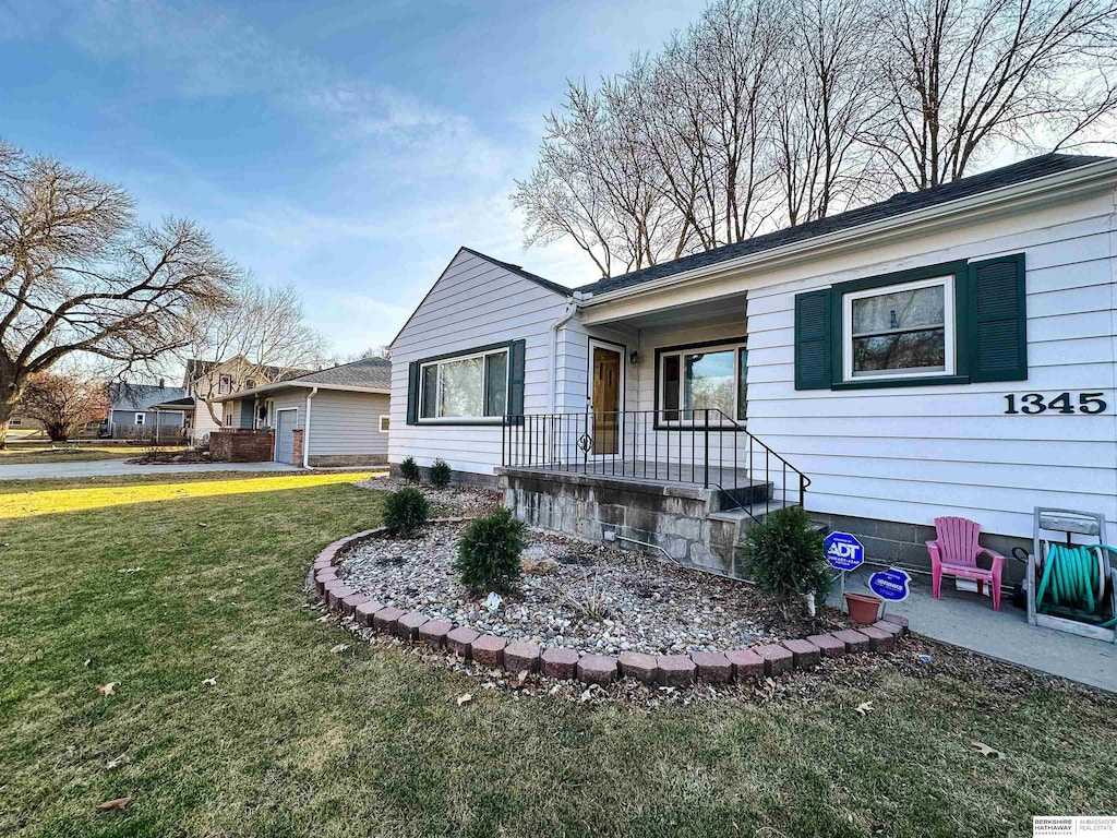 view of front of home featuring a front lawn and a patio