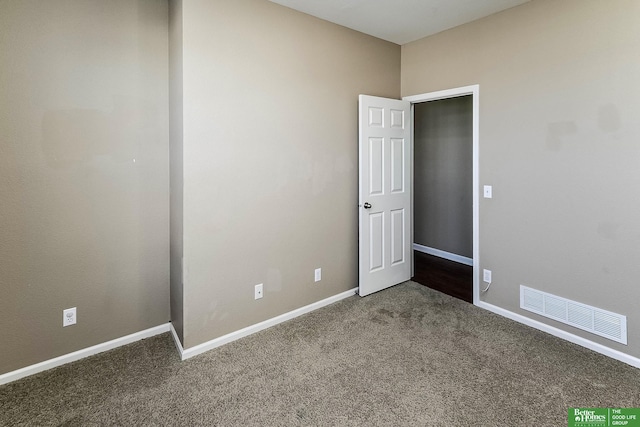 spare room with visible vents, carpet, and baseboards