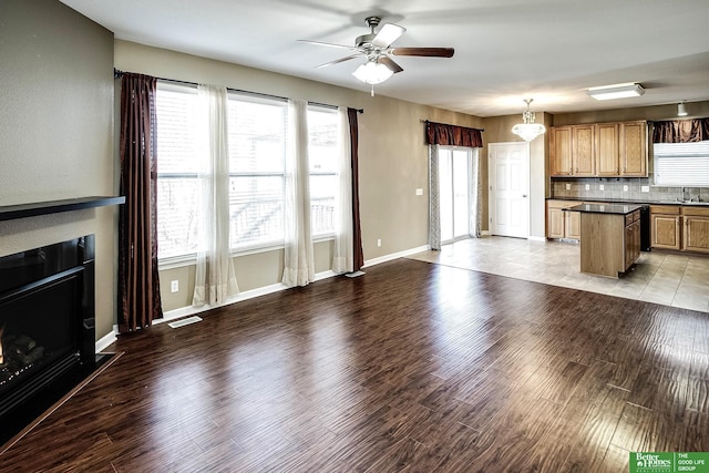 unfurnished living room with visible vents, baseboards, ceiling fan, and light wood finished floors