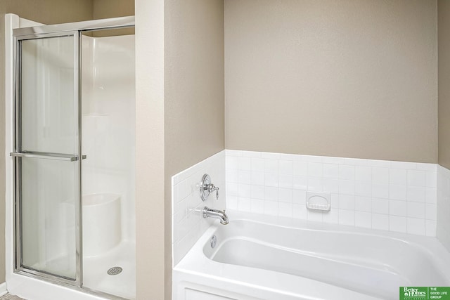 bathroom with a shower stall and a bath