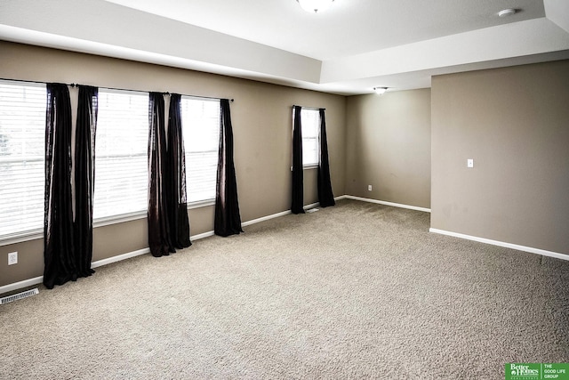 carpeted empty room with visible vents and baseboards