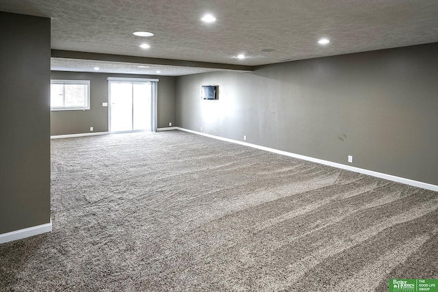 carpeted spare room featuring recessed lighting, a textured ceiling, and baseboards