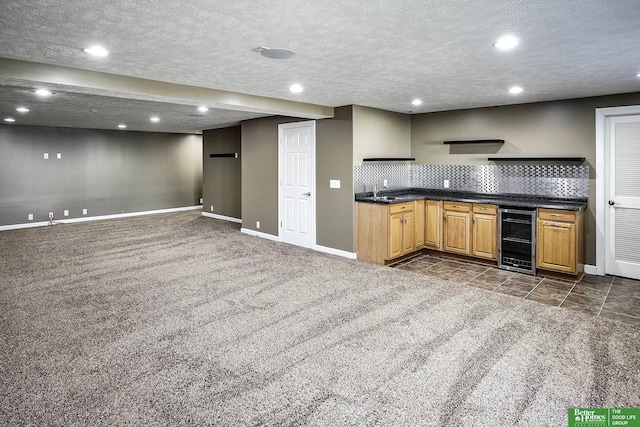 kitchen with dark countertops, backsplash, beverage cooler, a textured ceiling, and dark colored carpet