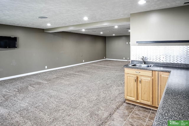 interior space with a textured ceiling, carpet flooring, recessed lighting, and a sink